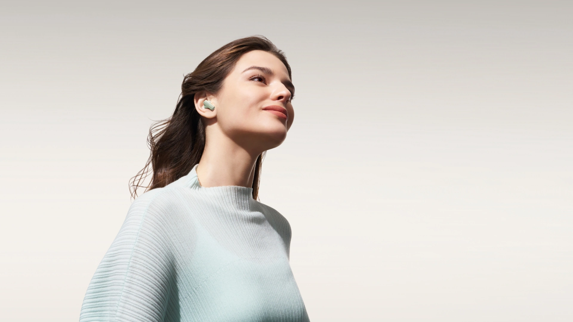 A woman wearing HUAWEI FreeBuds Pro 4 in Green