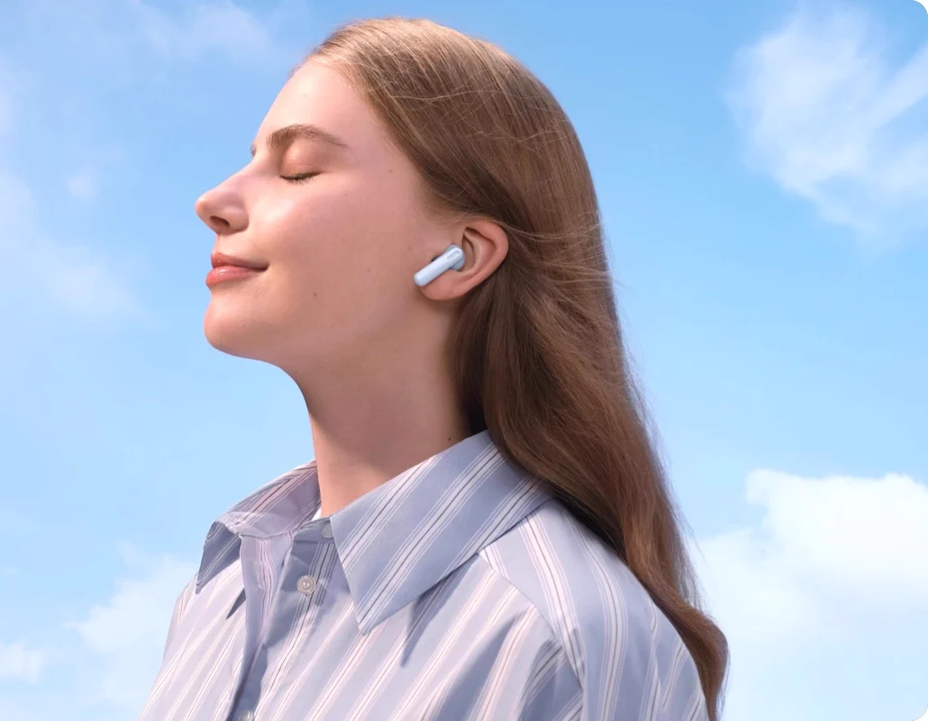 A woman with her eyes closed wearing the earbuds